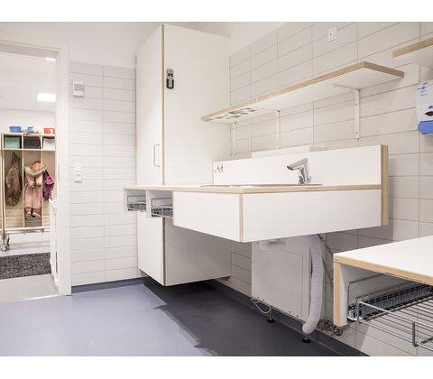 CE-mærket puslebord til institutioner 1300 x 900 mm fra ST Skoleinventar, inkl trådløs fjernbetjening og underlimet vask placeret til højre (set forfra)