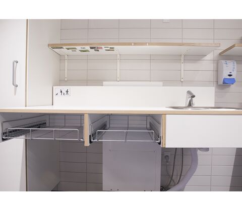 CE-mærket puslebord til institutioner 1300 x 900 mm fra ST Skoleinventar, inkl trådløs fjernbetjening og underlimet vask placeret til højre (set forfra)